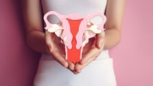 Female reproductive health concept. Woman hand holding uterus sh